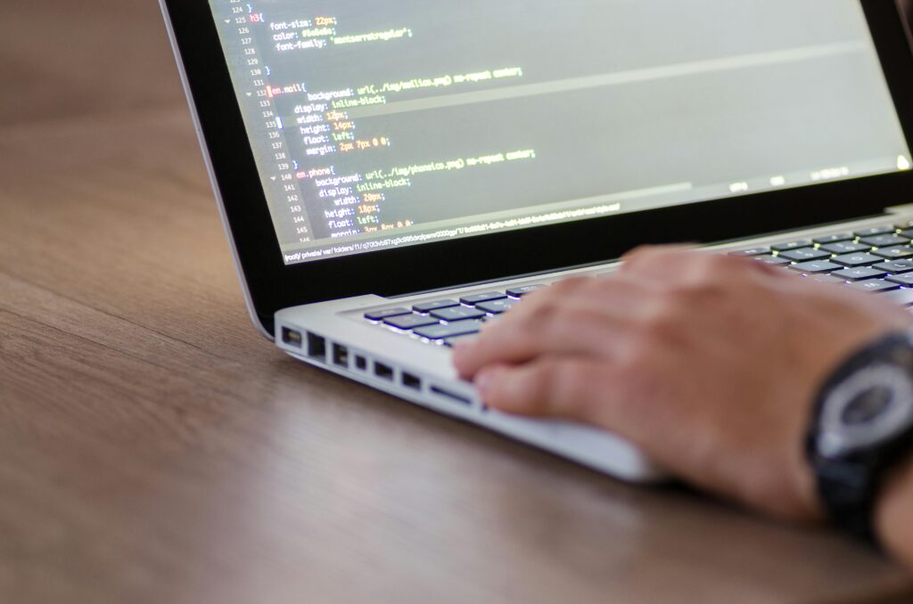 pexels-photo-574077-574077 Person coding on a laptop with HTML code on screen, showcasing development work.